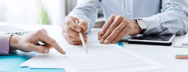 pair of hands pointing to a sheet of text