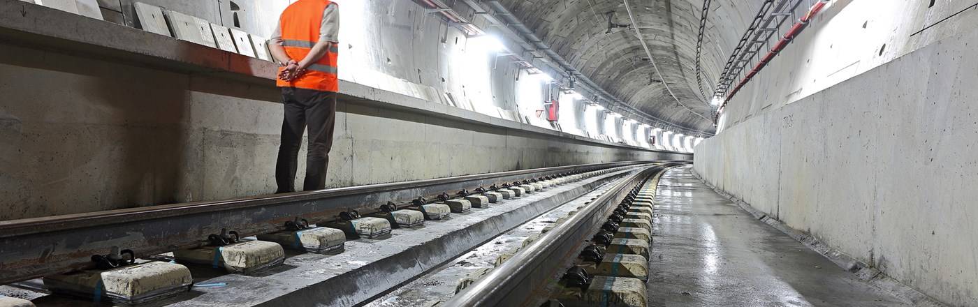 man standing on the side of a rail tunnel