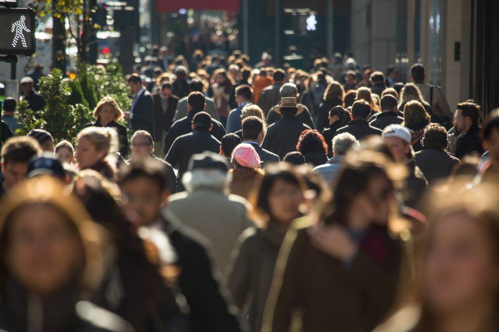 Crowd of anonymous people walking on a busy New York street during daytime