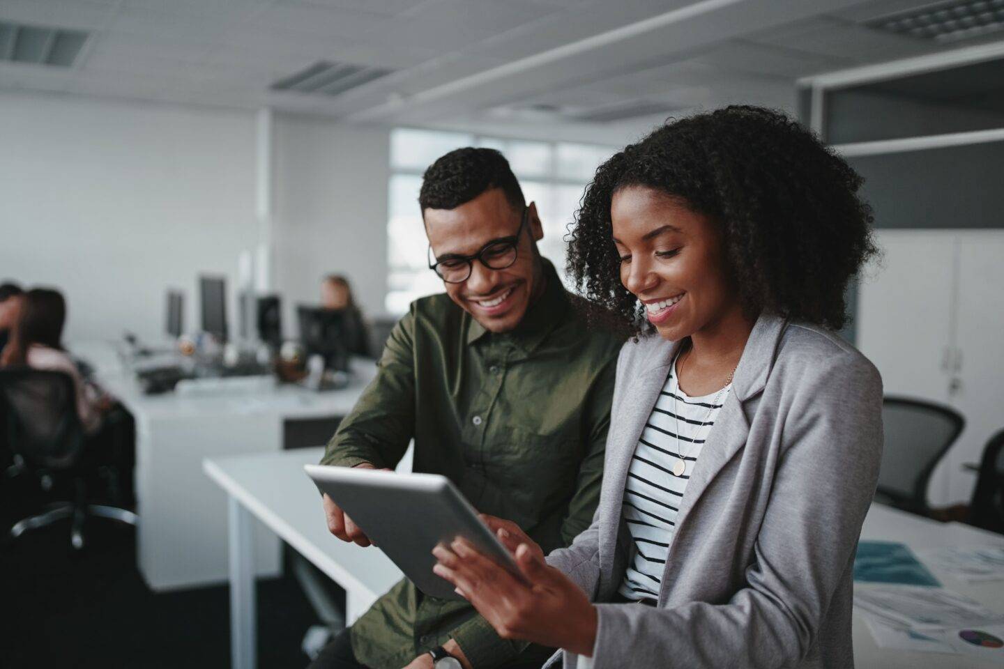 man and woman working on tablet