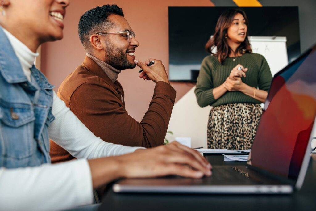 Group of diverse business people having a meeting in a boardroom. Young businesspeople smiling happily during a discussion. Multiethnic businesspeople working together as a team - Microsoft Partner