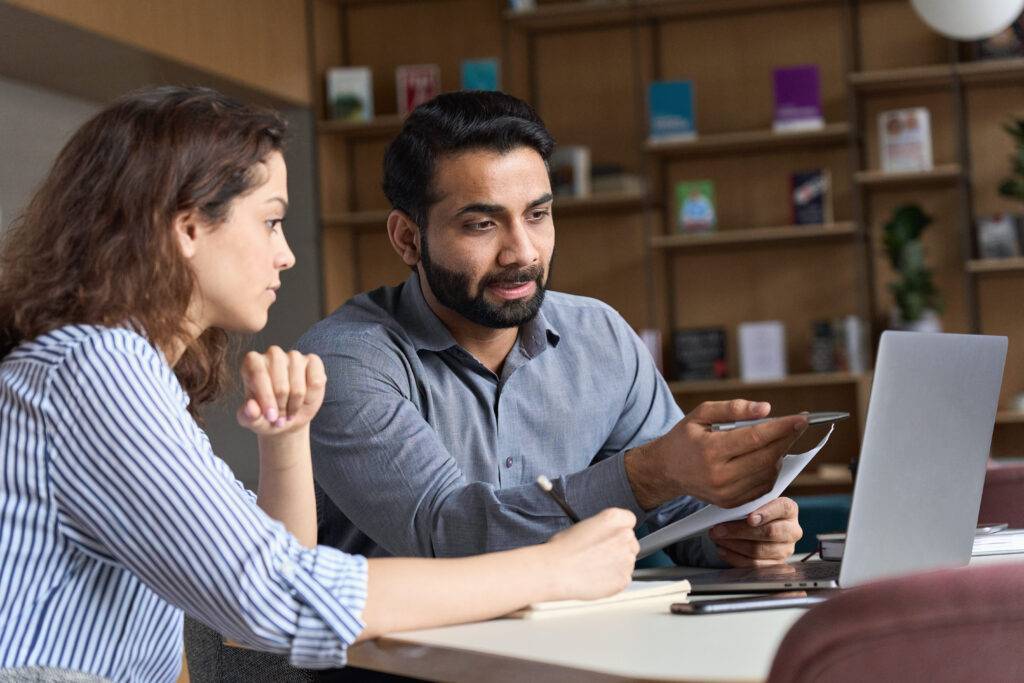 man and woman working together on laptop