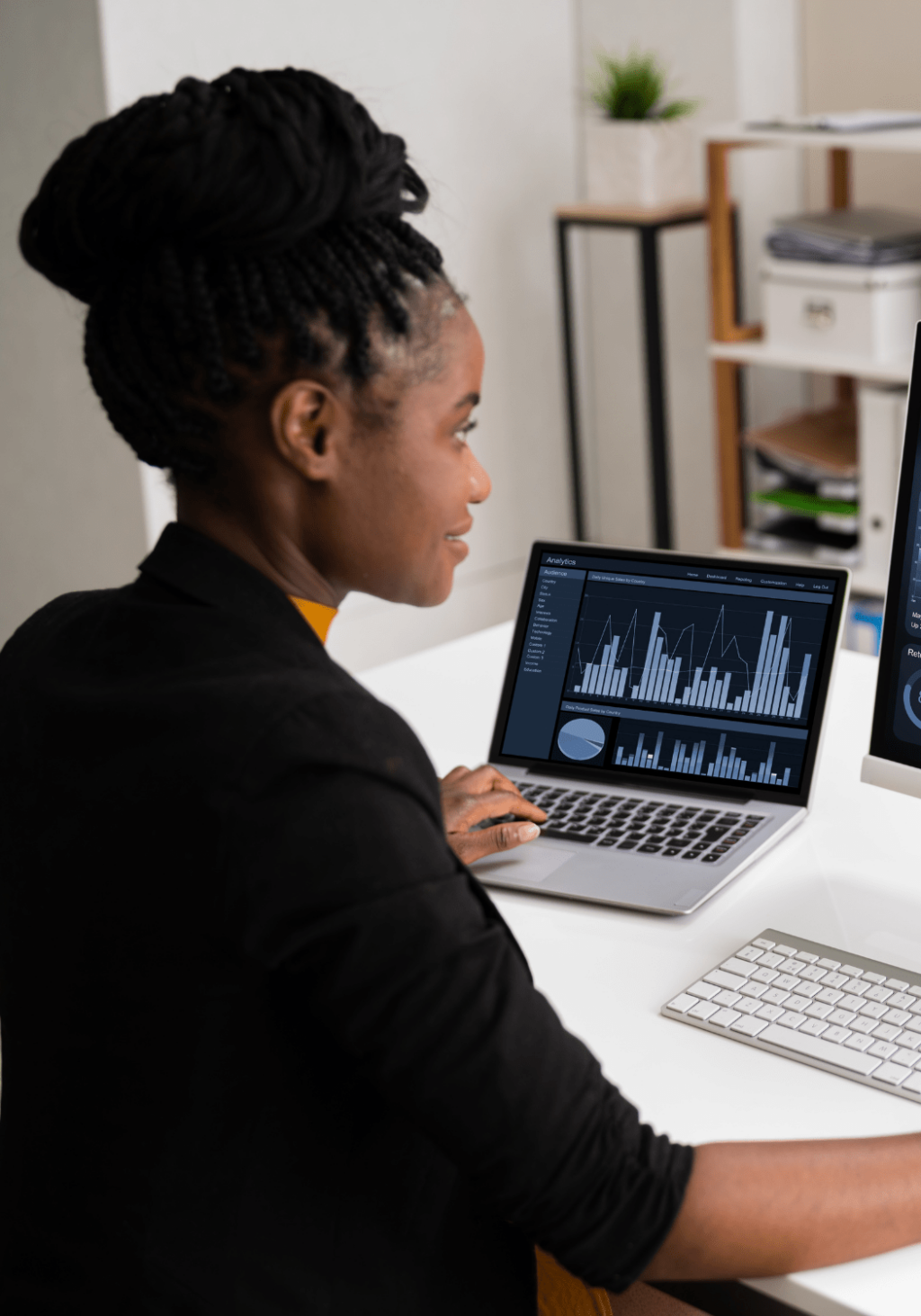 Woman working at desk with dashboards showing on screen